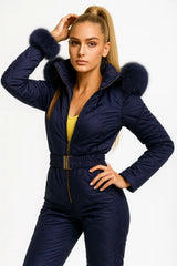 Women's navy blue quilted jumpsuit with fur hood and gold belt – elegant winter fashion outfit