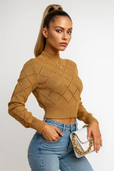 Women's camel knit sweater with diamond texture, paired with light jeans and white handbag